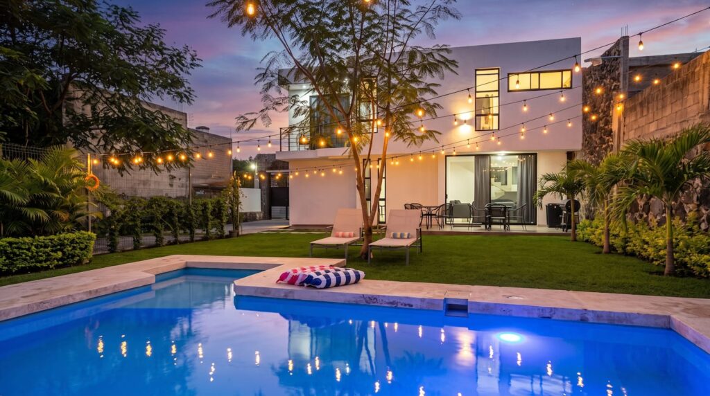 Alberca privada de Casa Luna al atardecer con luces encendidas